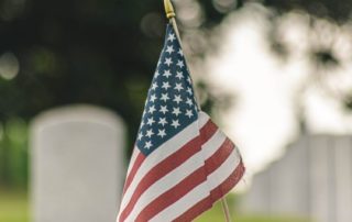 American Flag in a cemetery in front of a grave