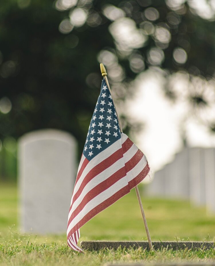 American Flag in a cemetery in front of a grave