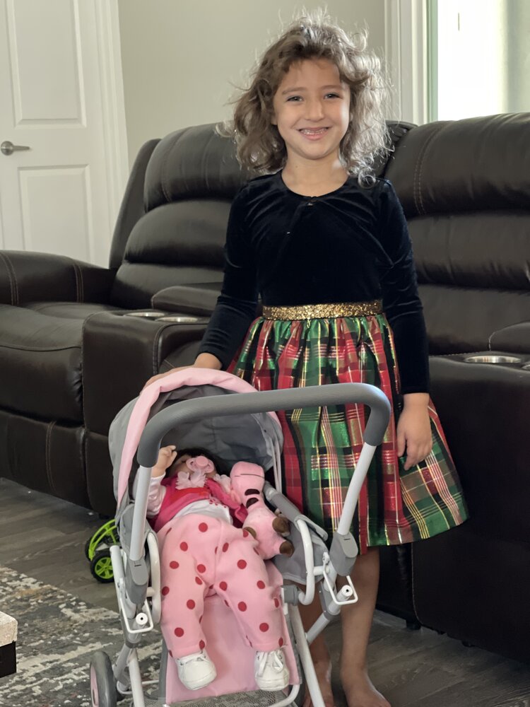 smiling girl with baby doll and stroller