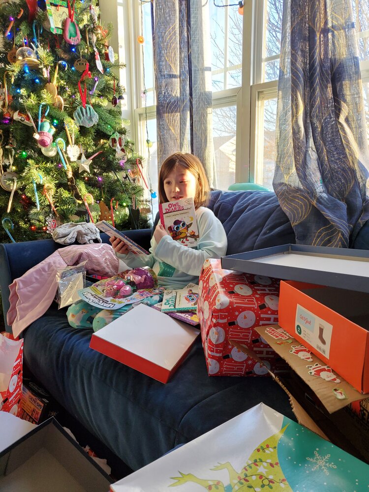 smiling girl opening Christmas gifts
