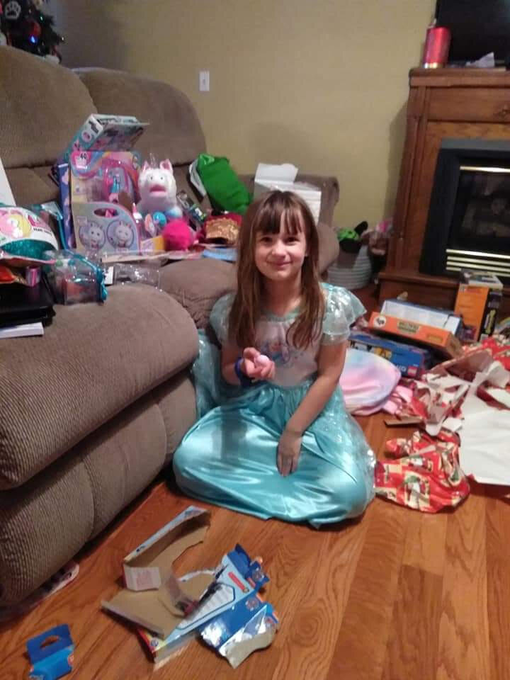a girl smiling with all her new Christmas presents